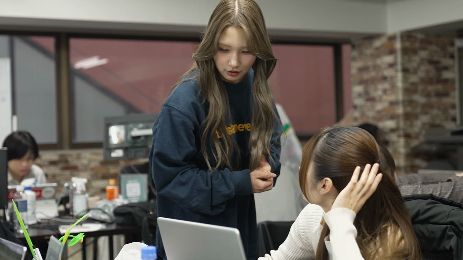 立って話す女性と、座って耳を傾けるメンバー