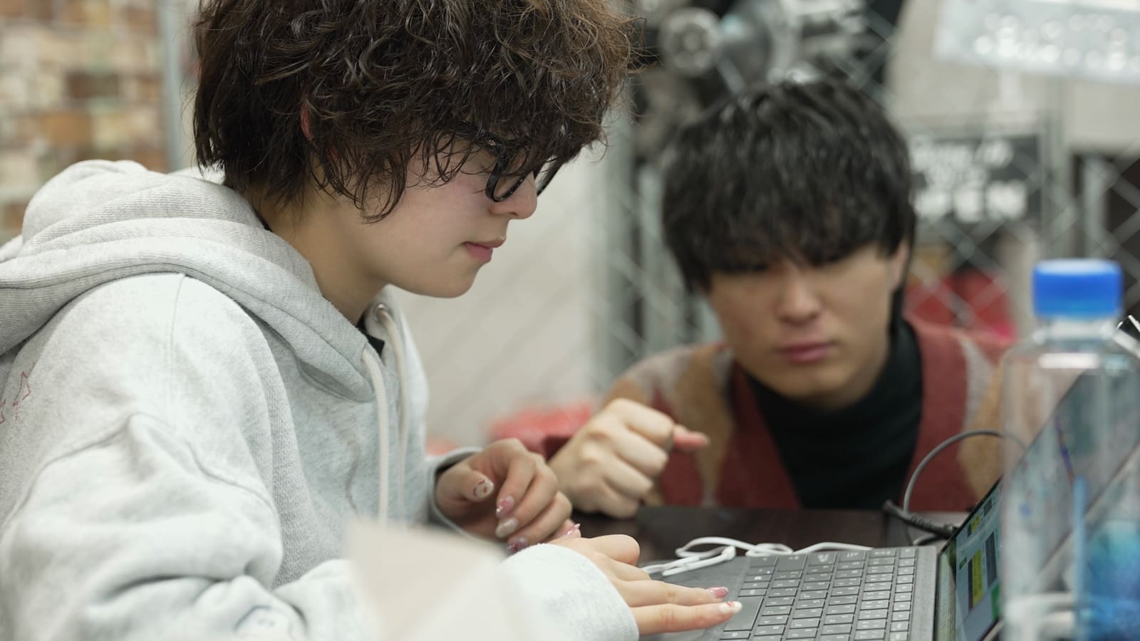 2人のメンバーが、ノートPCを覗き込んで相談する